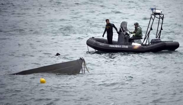 The prow of a submarine used to transport drugs illegally emerges as Spanish Guardia Civil's divers work to refloat it in Aldan, northwestern Spain