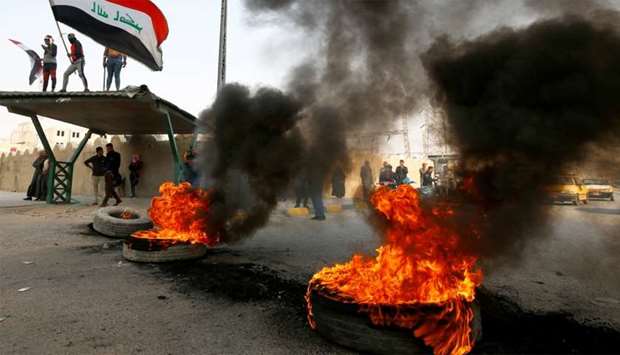 Iraq protesters burn tires to block a street during ongoing anti-government protests in Najaf