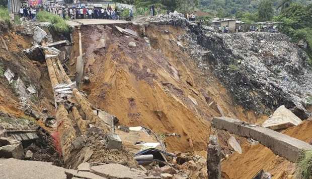 A road surface swept away by a landslide caused by torrential overnight rains is photographed in the Lemba district of Kinshasa. AFP