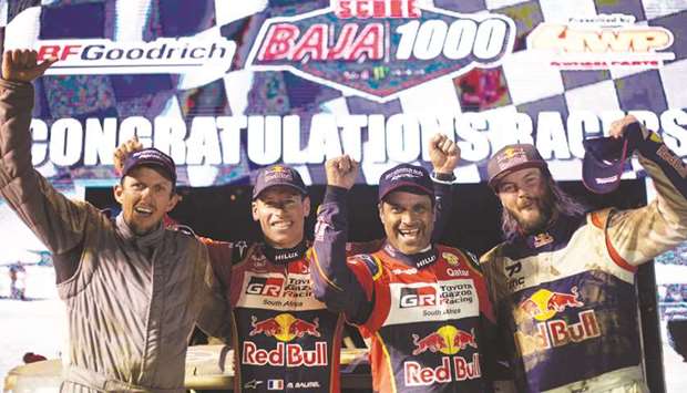 (From left) Co-drivers Dustin Helstrom and Mathieu Baumel, and drivers Nasser al-Attiyah and Toby Price pose on the podium ramp at the Baja 1000 in Baja California, Mexico, on Sunday. (Red Bull Content Pool)