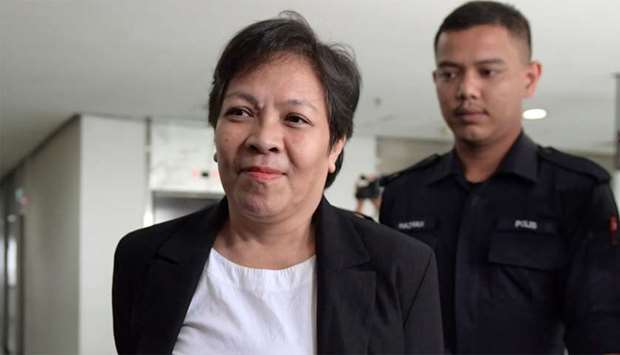 Maria Elvira Pinto Exposto, is escorted upon her arrival at the Shah Alam High Court
