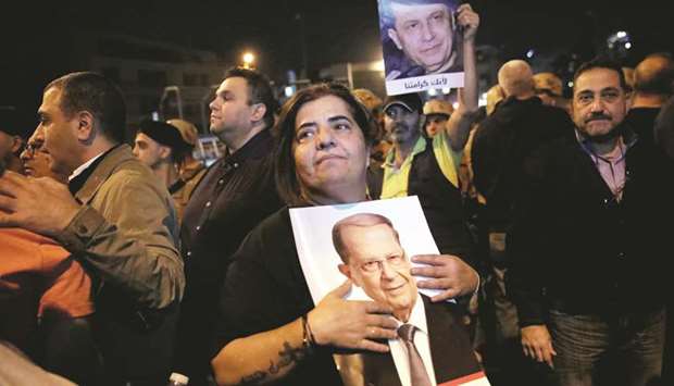 A supporter holds a picture of Lebanonu2019s President Michel Aoun during a demonstration in Hazmiyeh, yesterday.