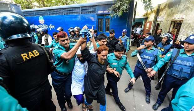 Police escort detainees (C) accused of allegedly plotting the Holey Artisan Bakery cafe attack, carried out by militants, to a courtroom for their trial in Dhaka