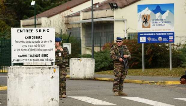 Soldiers stand at the entry of the 5th RHC (Fighter Helicopter Regiment) base, the regiment 7 of the soldiers killed in the helicopter crash in Mali belong to, in Uzein near Pau, southwestern France