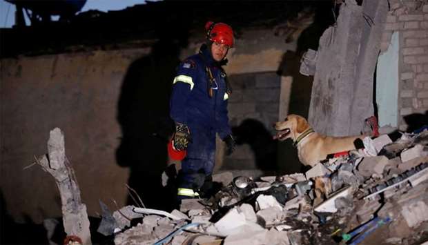 A member of the emergency personnel from Greece works at a damaged building, following Tuesday's powerful earthquake, in Thumane, Albania