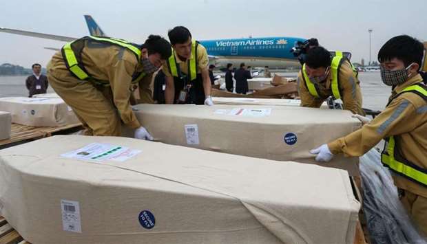 Ground personnel of Noi Bai International Airport preparing caskets containing the remains of Vietnamese victims to load to an ambulance in Hanoi.