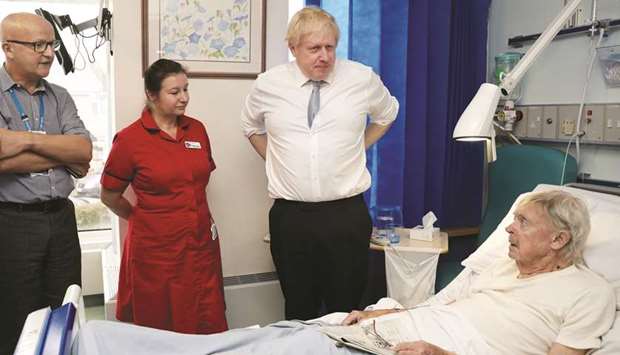 Prime Minister Boris Johnson speaks to patient Andrew Hall as he visits West Cornwall Community hospital in Penzance, Britain, yesterday.