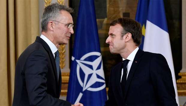 NATO Secretary General Jens Stoltenberg and French President Emmanuel Macron shake hands at the end of a news conference after their meeting at the Elysee palace in Paris