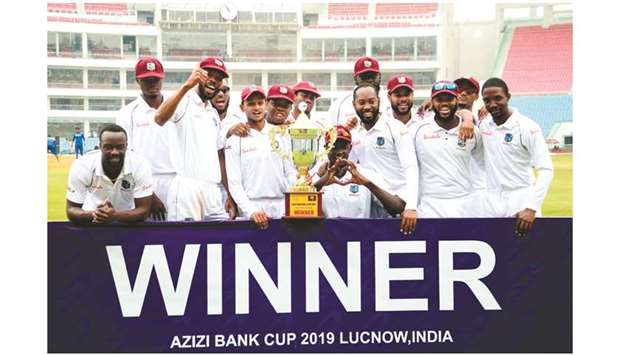 West Indies players celebrate with trophy after winning Test against Afghanistan in Lucknow yesterday. (AFP)