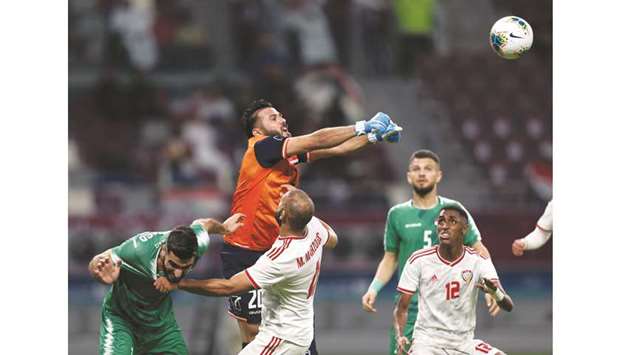 Iraq goalkeeper Mohamed Hameed Farhan (in orange and blue) makes a clearance during the match against the UAE yesterday.