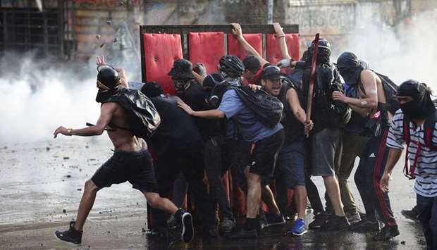 Demonstrators clash with riot police water cannon during a protest against the government in Santiago. Furious Chileans have since October 18 been protesting social and economic inequality, and against an entrenched political elite that comes from a small number of the wealthiest families in the country, among other issues.