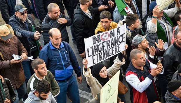 A woman marches with a sign reading in French u201cno to foreign interferenceu201d during a demonstration in the centre of  Algiers.