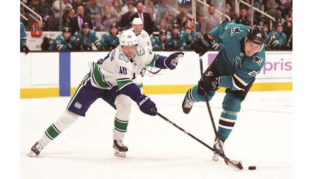 Vancouver Canucksu2019 Elias Pettersson (left) defends a shot by San Jose Sharksu2019 Timo Meier during the second period of the NHL game at SAP Center in San Jose, United States, on Saturday. (USA TODAY Sports)