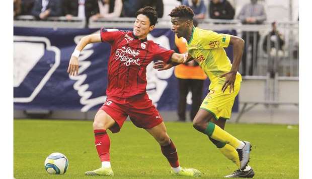 Bordeauxu2019s Hwang Ui-Jo (left) vies for the ball with Nantesu2019 Thomas Basila during the French Ligue 1 match in Bordeaux, southwestern France, yesterday. (AFP)