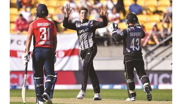 New Zealandu2019s Mitchell Santner (centre) celebrates after taking the wicket of Englandu2019s Chris Jordan in Wellington yesterday. (AFP)