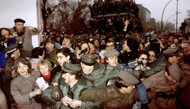 In this file photo taken on November 12, 1989 East and West German Police contain the crowd of East Berliners flowing through the recent opening made in the Berlin wall at Potsdamer Square