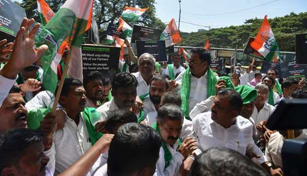 Activists hold placards abd Congress part flags during a protest called by Congress party and pro-farmer organisations to condem Narendra Modi led Indian governmentu2019s decision to sign the Regional Comprehensive Economic Partnership (RCEP) deal, at the Cantonment Railway Station in Bangalore
