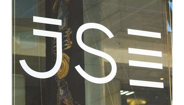 A logo sits on a glass door in the Johannesburg Stock Exchange (JSE) in the Sandton district of Johannesburg, South Africa (file). Moodyu2019s Investors Service on Friday held back from downgrading the governmentu2019s debt to junk, although it did lower the outlook to negative.