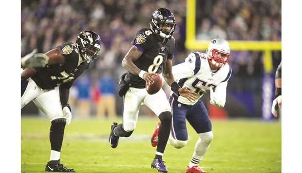 Baltimore Ravens quarterback Lamar Jackson (centre) runs past New England Patriots linebacker  Kyle Van Noy (right) during the fourth quarter in Baltimore on Sunday. (USA TODAY Sports)
