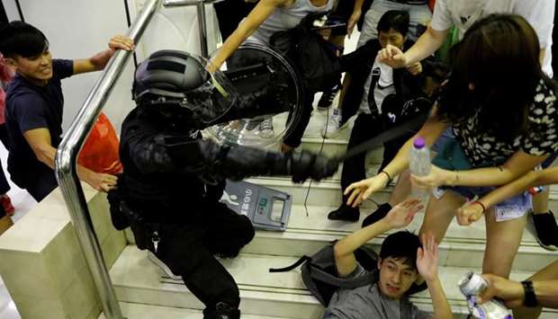 A riot police officer scuffles with protesters as he tries to detain a protester at a shopping mall in Tai Po in Hong Kong