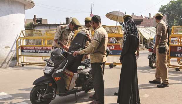 Policemen check a scooter at a security barricade on the road leading to the disputed religious site in Ayodhya.