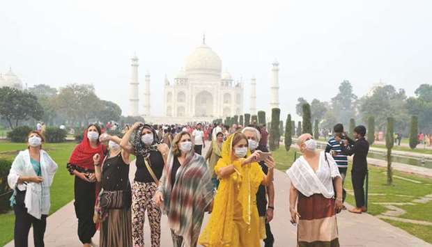 Foreign tourists wearing face masks visit the Taj Mahal under heavy smog conditions, in Agra yesterday. Authorities also parked a van with an air purifier near the iconic 17th-century marble mausoleum 250km south of Delhi.