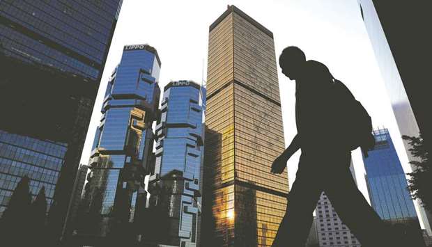 A man walks past buildings at a business district in Hong Kong, China.