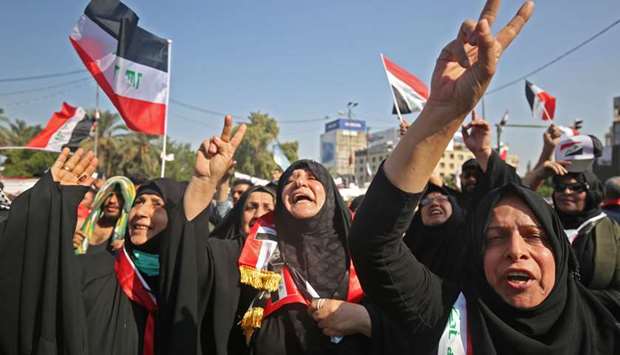 Iraqi women chant slogans and wave national flags as they take part in a protest in the capital Baghdadu2019s Tahrir Square during ongoing anti-government protests, yesterday.