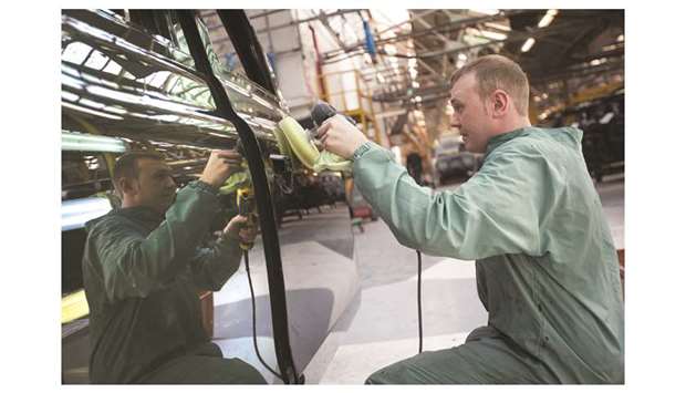 An employee polishes the door of a freshly painted black TX4 Euro 5 London taxi cab at the London Taxi Companyu2019s assembly plant, a unit of Zhejiang Geely Holding Co, in Coventry (file). The IHS Markit services Purchasing Managersu2019 Index (PMI) edged up to 50.0 u2014 which represents zero growth u2014 from 49.5 in September, which was one of the lowest readings since Britain was last in recession in 2009.