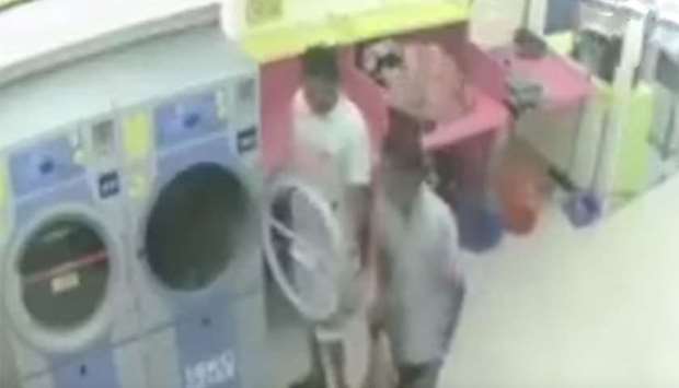 An image grab from a CCTV clip that shows the cat killers at the laundrette dryer