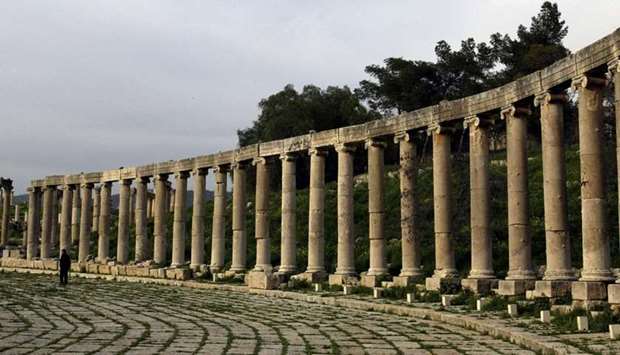 A file photo taken on April 2, 2003 shows a man walking amid the Roman columns of the ancient city of Jerash