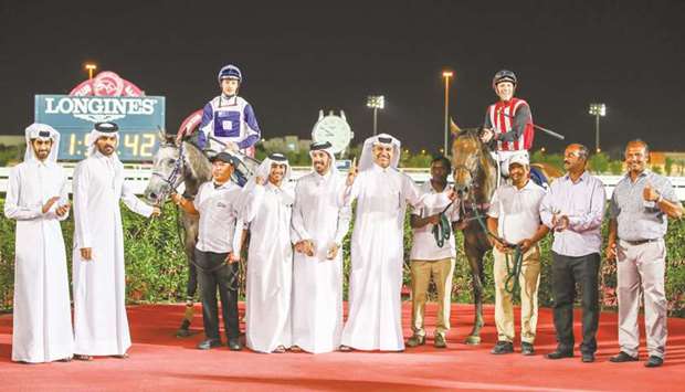 Trainer Jassim Mohamed Ghazali (sixth from right) poses with Khalifa bin Sheail al-Kuwariu2019s Festive, with Harry Bentley (third from left) astride, and Shaheen bin Khalid Shaheen al-Ghanimu2019s Hillside Dream, with Pier Convertino (fourth from right) in the saddle, after they finished first and second in the Qatar Cup at Al Rayyan Park respectively. PICTURES: Juhaim