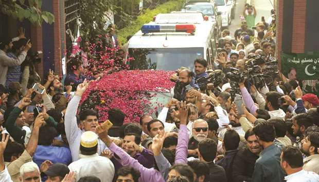 Supporters of jailed Pakistanu2019s former PM Nawaz Sharif garland his car as he leaves a hospital in Lahore yesterday.