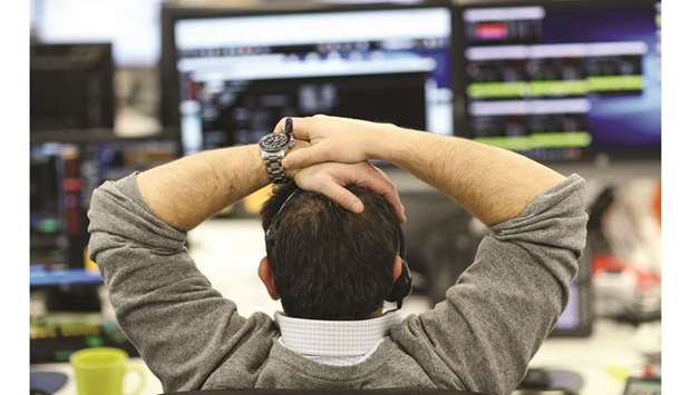 A broker looks at financial information on computer screens on the IG Index trading floor in London (file). Stock markets rose yesterday, boosted once more by hopes of a China-US trade deal, with some looking to December for an accord  between the two economic superpowers.