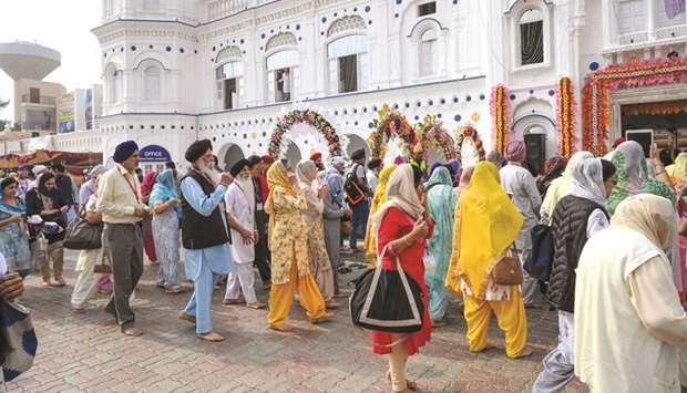 Sikh pilgrims arrive yesterday at a shrine in Nankana Sahib, some 75km west of Lahore, on the occasion of the 550th birth anniversary of Guru Nanak Dev.