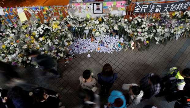 People gather near a makeshift memorial, paying tribute to Chow Tsz-lok, 22, a university student who died after he fell during a protest in Hong Kong, China
