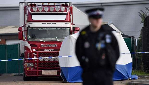 In this file photo taken on October 23, 2019, a police officer secures the cordon at the scene where a lorry, found to be containing 39 dead bodies, was discovered at Waterglade Industrial Park in Grays, east of London. AFP