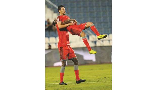 Al Duhailu2019s Yousef Msakni is  hoisted by a teammate after he  scored against Al Khor yesterday.