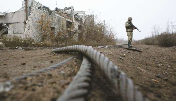 A Ukrainian serviceman patrols by a destroyed coal mine of Butovka, at the front line with  Russia-backed separatists, not far from the town of Avdiivka, in the Donetsk region. Ukraineu2019s army and separatists have postponed the planned pullback of troops in the war-torn east by 24 hours, international monitors said.
