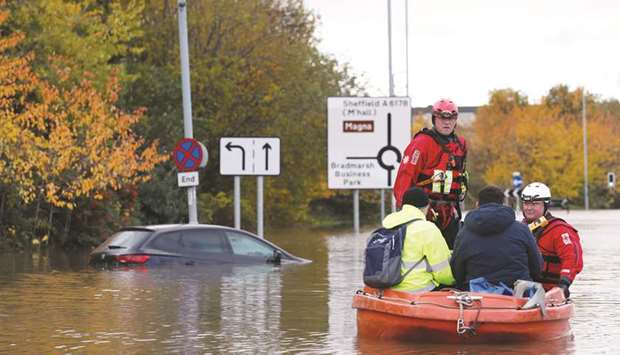 Firefighters and first responders rescue people stranded on a flooded road in central Rotherham, near Sheffield, Britain, yesterday.