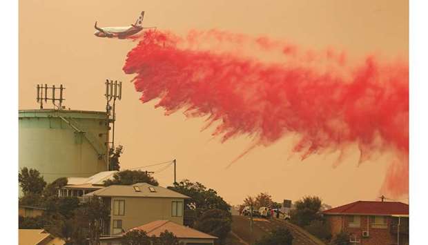 A water bombing plane drops fire retardant on a bushfire in Harrington, Australia, yesterday.
