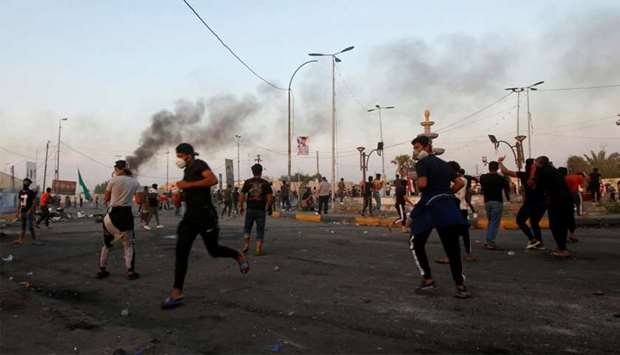 Demonstrators clash with members of Iraqi security forces during the ongoing anti-government protests near the Governorate building of Basra