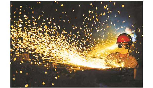 A worker wearing protective glasses welds steel products at a heavy equipment manufacturing factory in Luoyang, Henan province (file). Chinau2019s manufacturing sector weakened in October on declining demand and a knock from the Sino-US tariff war, reinforcing the case for Beijing to keep the stimulus coming.
