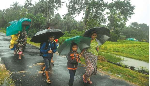 Villagers holding umbrellas carry their belongings on their way to enter a relief centre in Bakkhali near Namkhana in West Bengal yesterday.