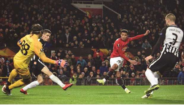 Manchester Unitedu2019s striker Mason Greenwood (2nd R) shoots to score the opening goal past FK Partizanu2019s Serbian goalkeeper Vladimir Stojkovic (L) during their UEFA Europa League Group L football match at Old Trafford in Manchester on Thursday.