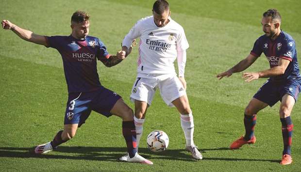 Real Madridu2019s Eden Hazard (right) vies for the ball with Huescau2019s Pablo Maffeo during the La Liga match in Valdebebas, northeastern Madrid, yesterday. (AFP)