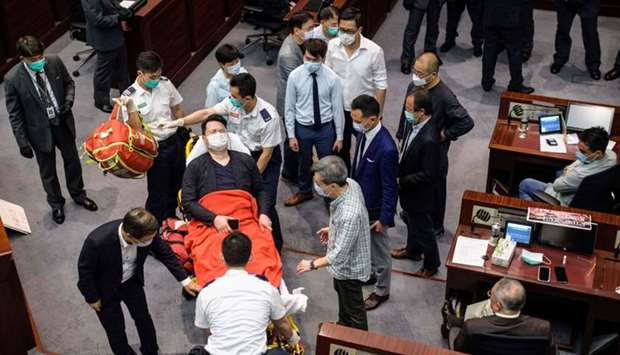 In this file photo taken on May 8, 2020, pan-democratic legislator Andrew Wan Siu-kin is taken away by paramedics after scuffles with security and pro-China legislators during a key committee meeting at the Legislative Council in Hong Kong