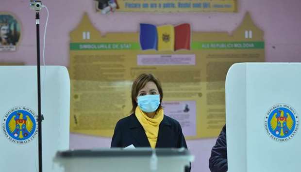 Presidential candidate Maia Sandu wearing a face mask walks to cast her ballot at a polling station during Moldova's presidential election in Chisinau