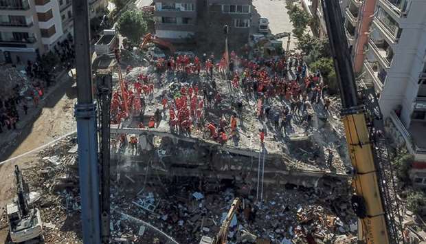 An aerial view that shows volunteers and rescue personnel searching for survivors in a collapsed building in Izmir