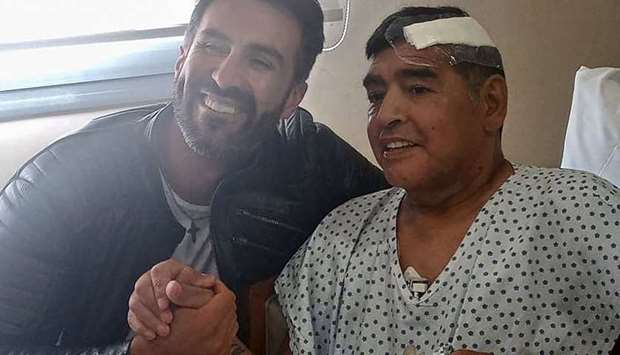 Argentine football legend Diego Maradona (R) shaking hands with his doctor Leopoldo Luque in Olivos, Buenos Aires province, Argentina